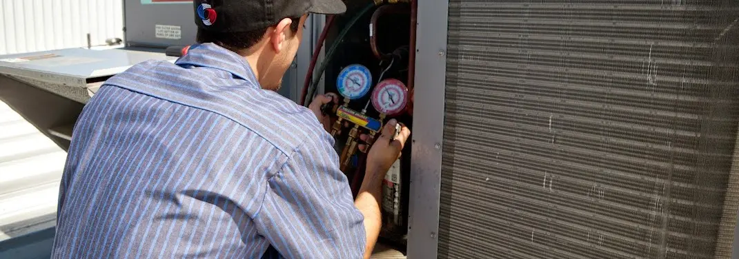 HVAC technician servicing a condenser unit in Wareham
